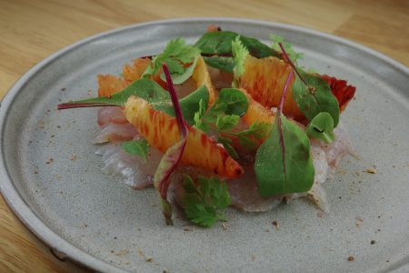 Le Gravlax de Daurade au Saké, Poivre Timut et Oranges Sanguines est l’une des entrées de la carte de juin 2024. 
Le Restaurant Chez Les Garçons est situé en plein cœur du centre historique de Rennes, à deux pas de la Cathédrale Saint Pierre et de la place des Lices. Nous vous proposons des plats raffinés, authentiques, renouvelés au fil des saisons dans un cadre chaleureux et une ambiance cosy et décontractée parfaite pour vous accueillir à l’occasion de vos soirées en tête à tête, en famille, entre amis ou pour partager un moment avec vos collègues.